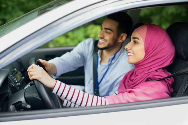 Cuidar do marido árabe ensinando sua esposa muçulmana em Hijab para dirigir carro - Foto, Imagem