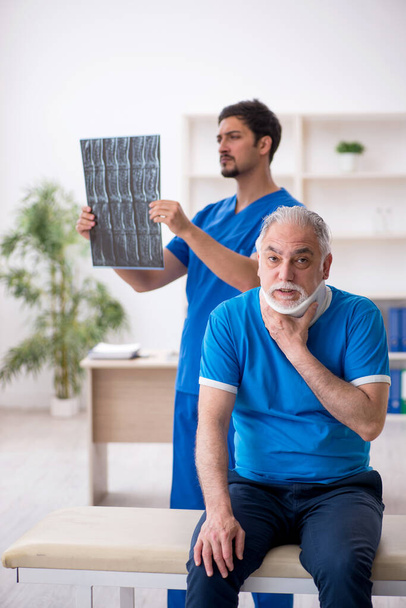 Anciano paciente masculino visitando joven médico radiólogo - Foto, Imagen