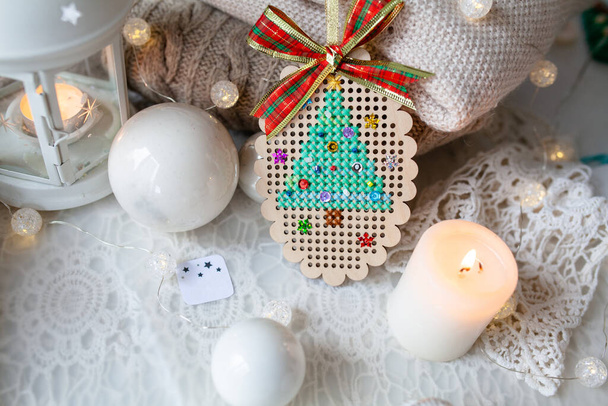 Beautiful winter decor for the new year. Christmas tree embroidery on a wooden base - Photo, Image