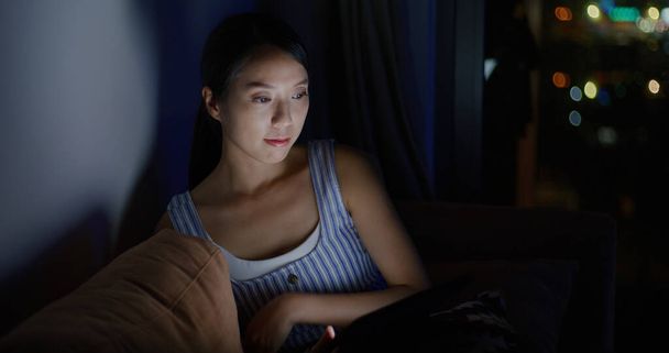 Mujer mira el ordenador tableta en casa por la noche - Foto, Imagen
