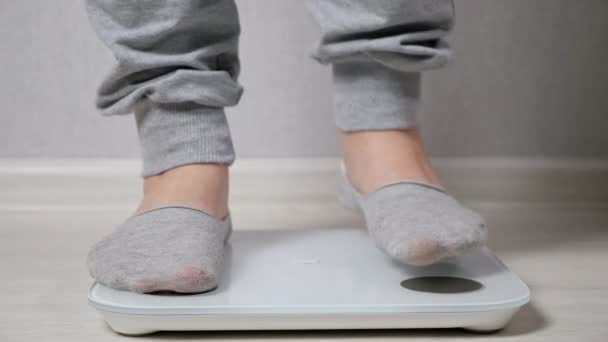 Femme se tient sur balance électronique pour mesurer le poids gros plan - Séquence, vidéo