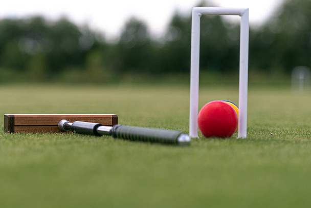 mazo de croquet, wicket y bolas de colores en un césped verde - Foto, Imagen