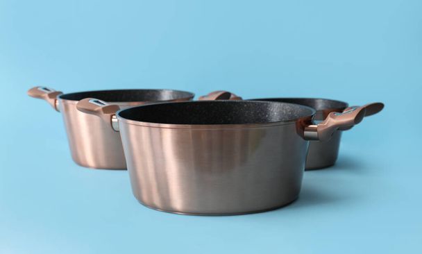 Roestvrij koken potten op kleur achtergrond - Foto, afbeelding