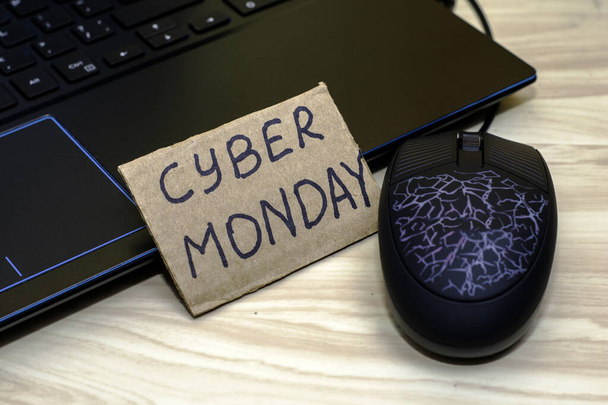 signo de cartón con la inscripción Cyber Monday al lado de la computadora portátil - Foto, imagen