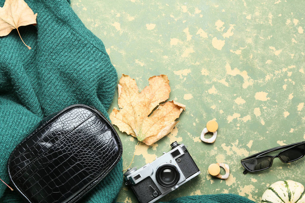 Модные аксессуары, свитер и фотокамера на цветном фоне - Фото, изображение