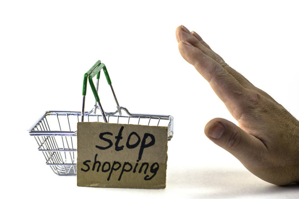 the concept of abandoning purchases of reasonable consumption is a rigidly pushed shopping basket with the inscription stop shopping on a white background - Photo, Image