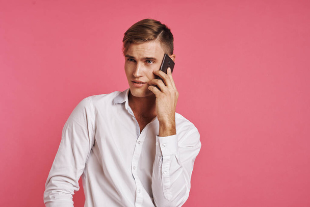 portrait of a man in a white shirt talking on the phone studio lifestyle - 写真・画像