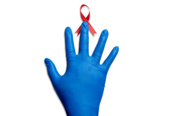 Red ribbon and medical glove with white background. Hiv Aids ribbon awareness - Foto, afbeelding