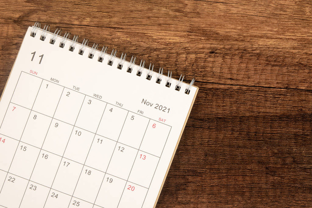 Calendario de escritorio 2021 en noviembre mes, Vista superior del calendario para el organizador a la planificación sobre fondo de mesa de madera. Concepto de reunión de planificación empresarial - Foto, imagen