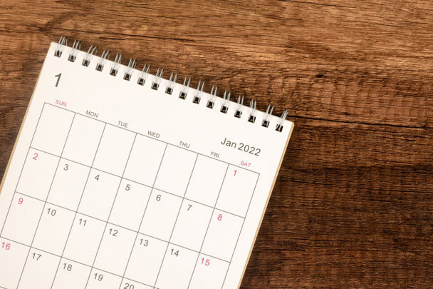 Calendario de escritorio 2022 en enero mes, Vista superior del calendario para el organizador a la planificación sobre fondo de mesa de madera. Concepto de reunión de planificación empresarial - Foto, imagen