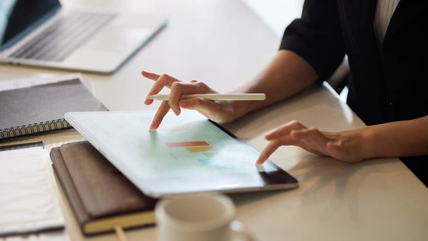 Ausgeschnittenes Bild einer Geschäftsfrau mit Tablet, Fingertippen, Berühren eines modernen digitalen Tablet-Bildschirms, um an Datenreport zu arbeiten. - Foto, Bild