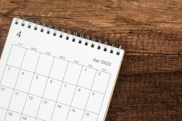 Calendario de escritorio 2022 en abril mes, Vista superior del calendario para el organizador a la planificación sobre fondo de mesa de madera. Concepto de reunión de planificación empresarial - Foto, imagen