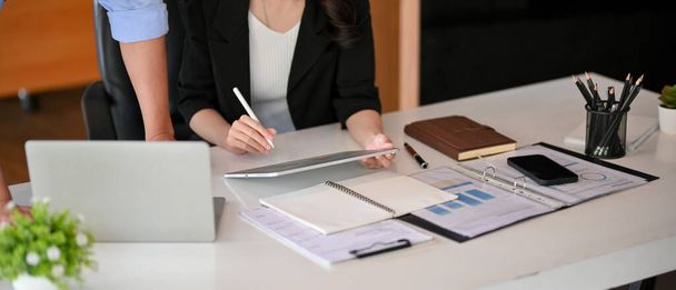 Recorte de jefe masculino y gerente ejecutivo femenino consultan estrategia de negocio en su lugar de trabajo. - Foto, imagen