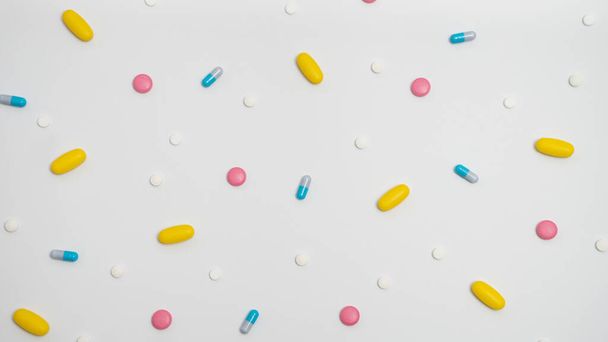 Variedad de medicamentos en cápsulas y píldoras de diferentes colores sobre un fondo blanco - Foto, Imagen