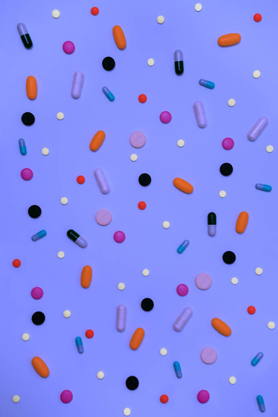 Verscheidenheid van drugs in capsules en pillen van verschillende kleuren op een witte achtergrond - Foto, afbeelding