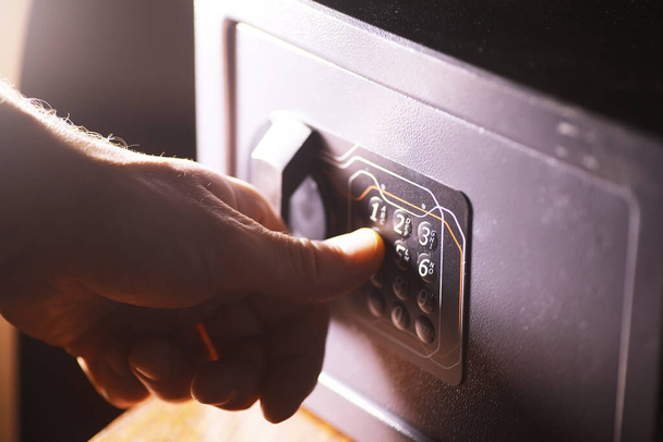 Стальной сейф с деньгами. Вручную положить пароль в сейф в гостиничном номере - Фото, изображение