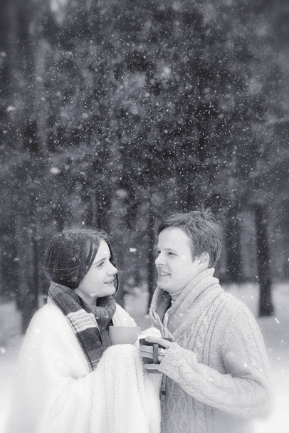 A loving couple on a winter walk. Man and woman on a date in the park in winter. Friends in winter park - Photo, Image