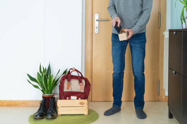 Homme laissant les clés, téléphone portable, chaussures et sac à dos correctement quand il rentre à la maison. Concept covid-19. Coronavirus. - Photo, image