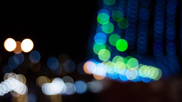 Abstract evening night shimmering bokeh background effect street outside near cafe restaurant. Defocused urban city life blur golden light bulbs garlands. Christmas New Year party holiday concept.  - 写真・画像