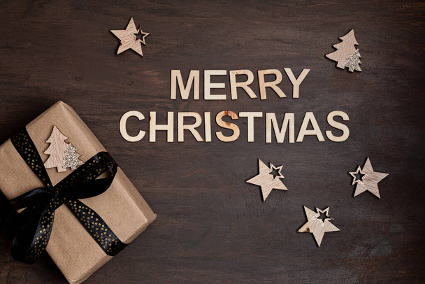 Kerst achtergrond met geschenkdoos over houten achtergrond. Kerstfeest, groeten, voorbereiding voor de wintervakantie. Feestelijke mockup, bovenaanzicht, vlak met kopieerruimte - Foto, afbeelding