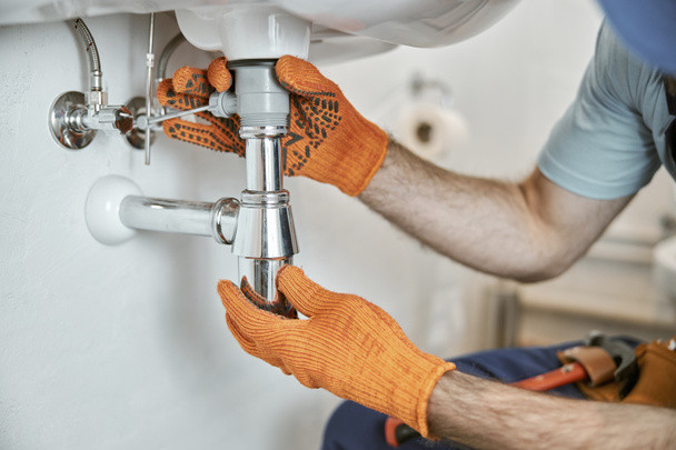 Férfi vízvezeték szerelő kezét rögzítő fém mosogató cső - Fotó, kép