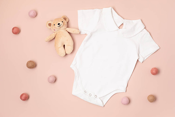 Mockup of white infant bodysuit made of organic cotton with eco friendly baby toys. Onesie template for brand, logo, advertising. Flat lay, top view - Photo, Image