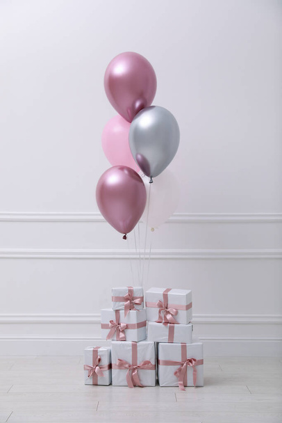 Many gift boxes and balloons near white wall in room - Valokuva, kuva