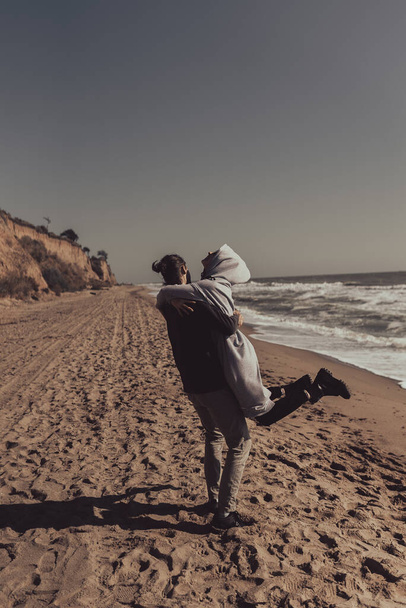 Muž a žena v náručí na pobřeží - Fotografie, Obrázek