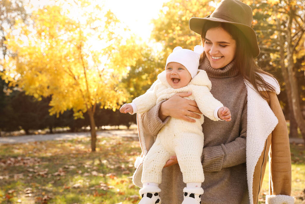 Happy mother with her baby daughter in park on sunny autumn day, space for text - Foto, Imagem