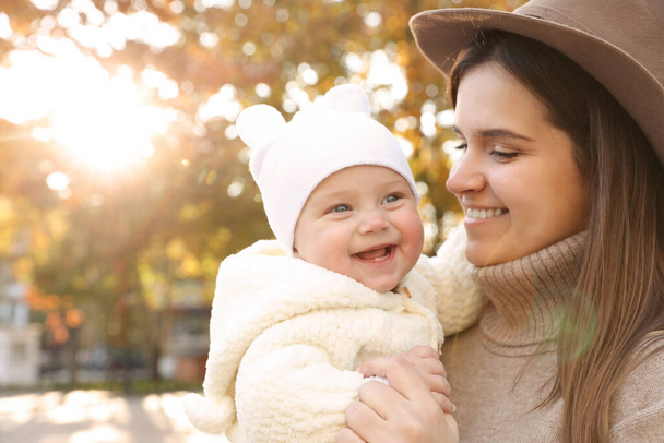 Happy mother with her baby daughter outdoors on autumn day, space for text - Foto, Imagem