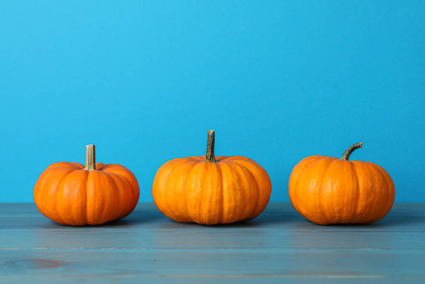 Fresh ripe pumpkins on turquoise wooden table, space for text - Φωτογραφία, εικόνα