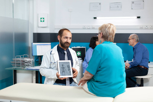 Medico che mostra l'immagine dello scheletro umano su tablet moderno - Foto, immagini