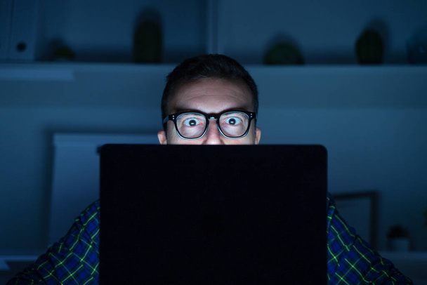 Un ragazzo geek che usa il computer portatile di notte - Foto, immagini