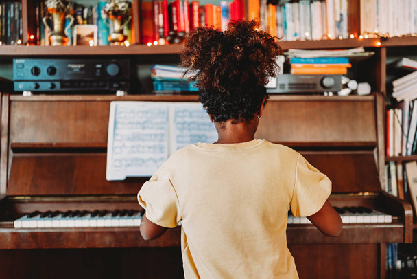 Musical education. Happy black girl playing the piano at home - Foto, afbeelding