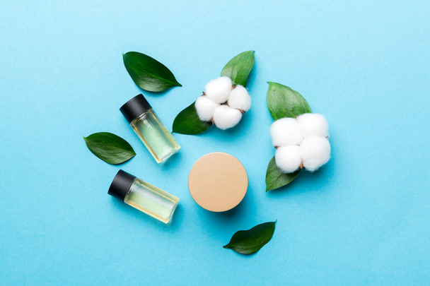 Produtos cosméticos orgânicos com flor de algodão e folhas verdes em fundo de madeira. Depósito plano. - Foto, Imagem
