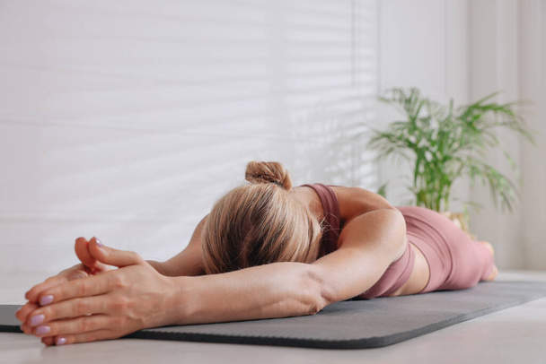 Woman practicing yoga on floor at home - Photo, Image