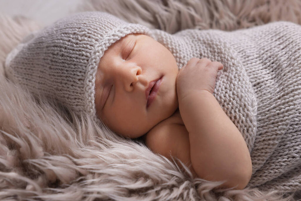 Adorable newborn baby lying on faux fur, closeup - Foto, imagen