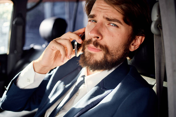Geschäftsmann mit Bart telefoniert auf Autofahrt - Foto, Bild