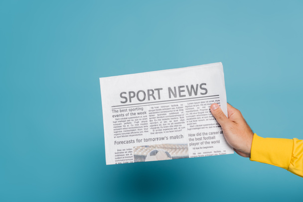 cropped view of man holding newspaper with sport news on blue - Fotoğraf, Görsel