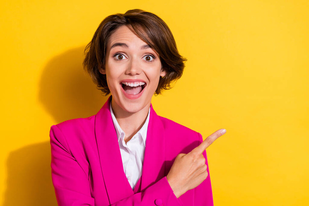 Portrait of attractive cheerful businesswoman demonstrating copy space new offer isolated over bright yellow color background - Fotó, kép