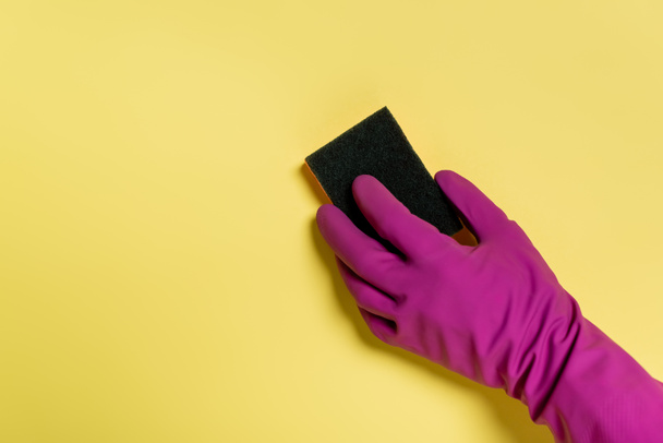 częściowy widok na środek czyszczący w gumowej rękawiczce trzymającej gąbkę na żółto - Zdjęcie, obraz
