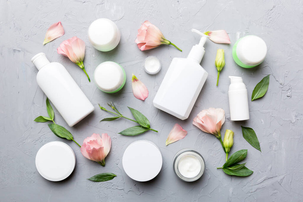Composition with cosmetic products and beautiful roses on cement background. Flat lay. - Zdjęcie, obraz