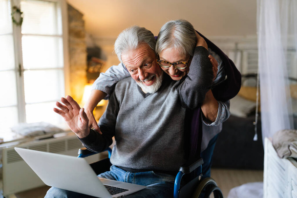 Happy senior couple using laptop at home and having fun together. Technology people concept - Φωτογραφία, εικόνα