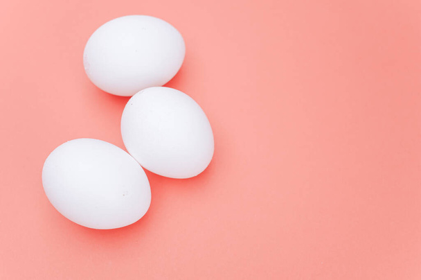 organic white eggs on a white salmon pink  surface with copy space for text - Foto, immagini