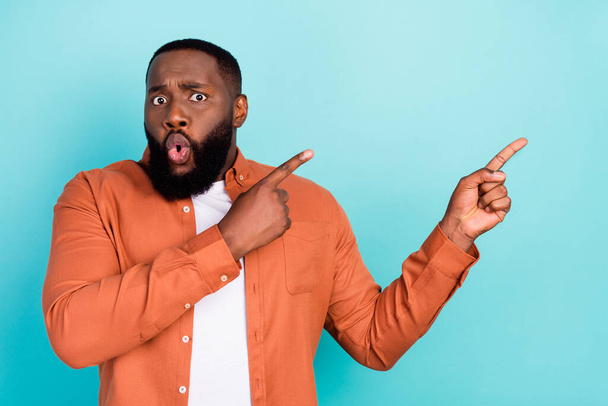 Photo of young black man amazed shocked point fingers empty space advertise promo isolated over turquoise color background - Photo, Image