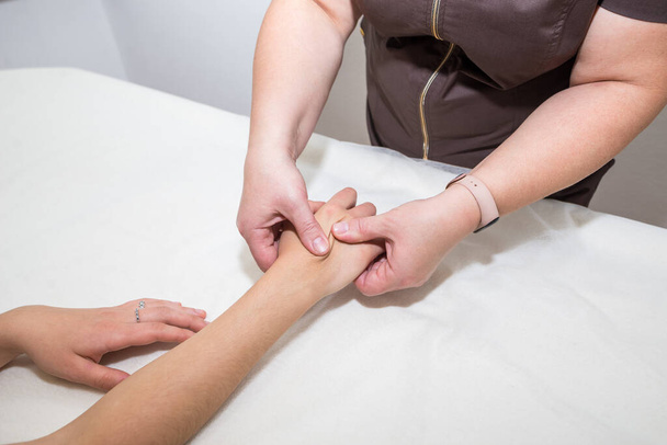 Closeup of a masseur doing a hand massage to a girl - Photo, image
