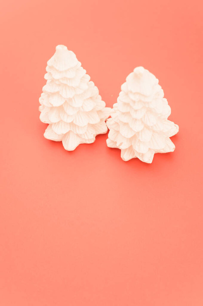 isolated decorative coniferous trees Christmas decor against a salmon color background - Foto, afbeelding