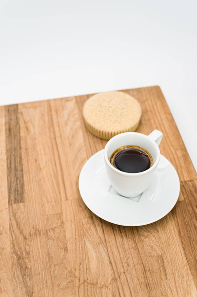 café expreso y torta orgánica de harina de trigo sarraceno sobre un fondo de madera y blanco con espacio para copiar - Foto, Imagen