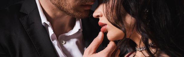 Şehvetli esmer kadının dudaklarına dokunan genç adamın kırpılmış görüntüsü. - Fotoğraf, Görsel