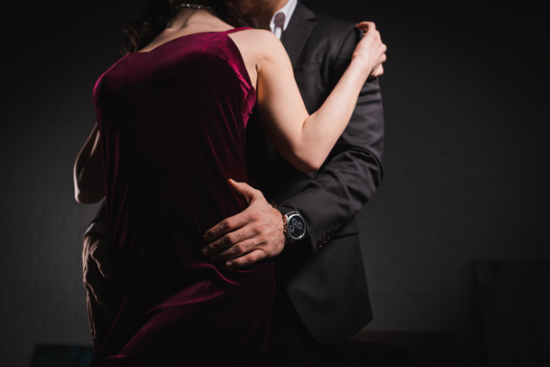 partial view of man in suit embracing hips of elegant woman at night - Photo, Image